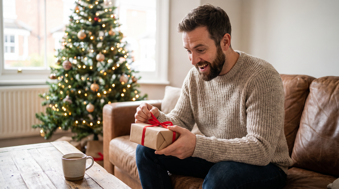 Homme barbu qui ouvre un cadeau de Noël personnalisé près du sapin