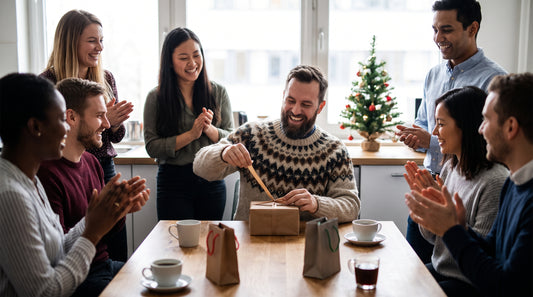 Cadeau Secret Santa drôle pour collègue : un homme barbu rit en ouvrant son paquet devant son équipe au bureau