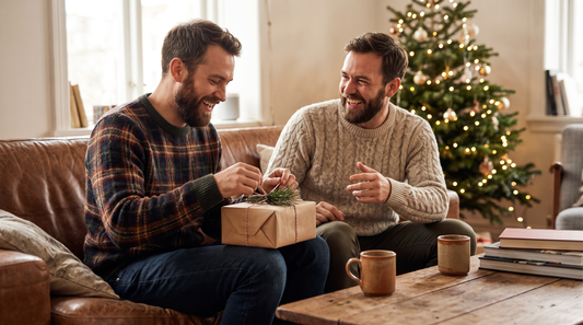 Cadeau de Noël pour son meilleur ami : deux amis barbus rient en ouvrant un cadeau devant le sapin